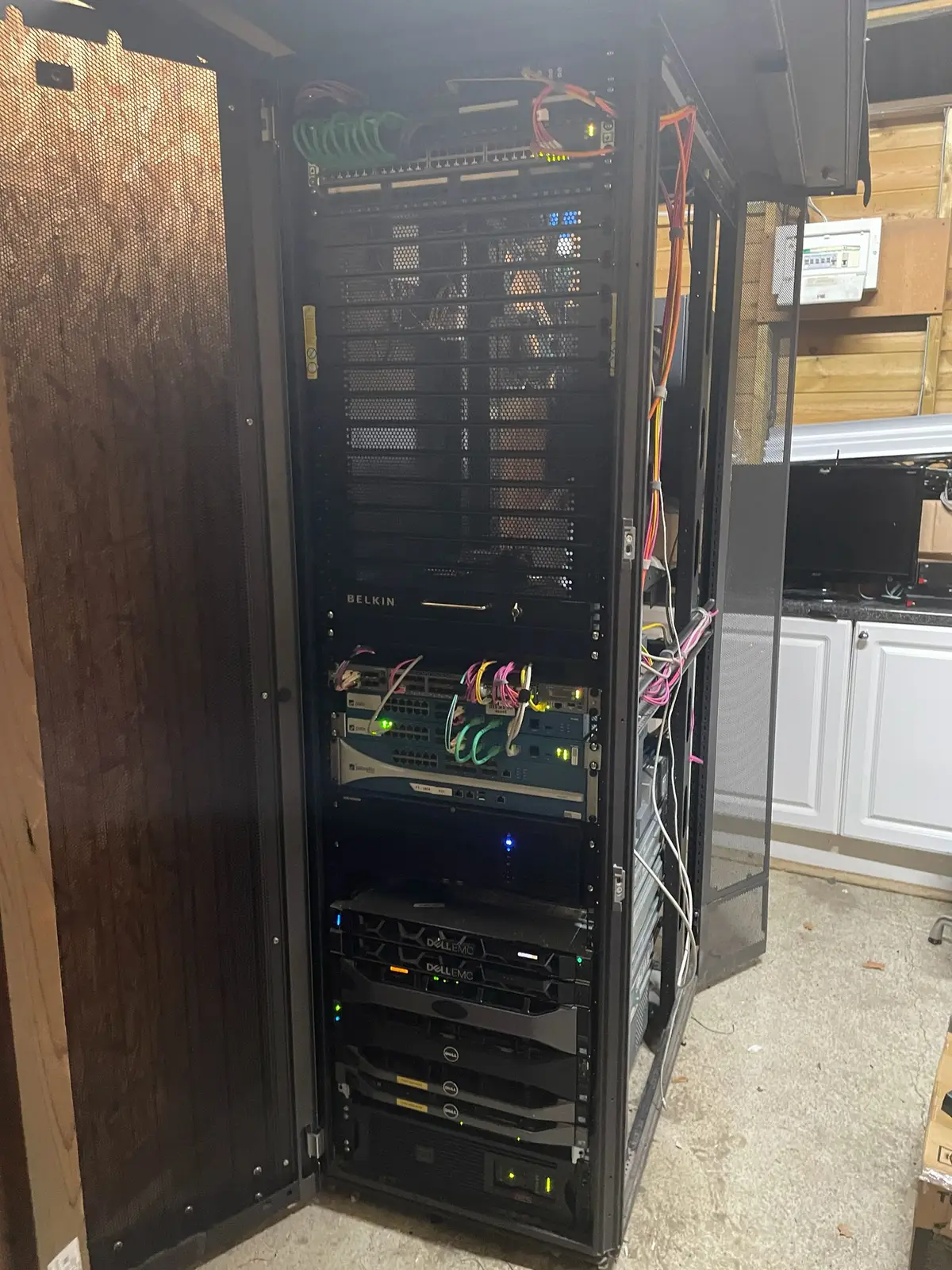 Full-height comms cabinet with labelled switches and patch cabling